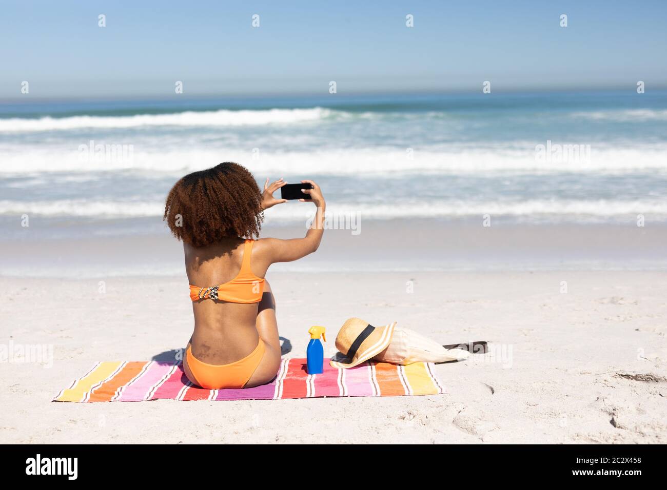 afroamerikanische Frau, die ein Selfie am Strand nimmt Stockfoto