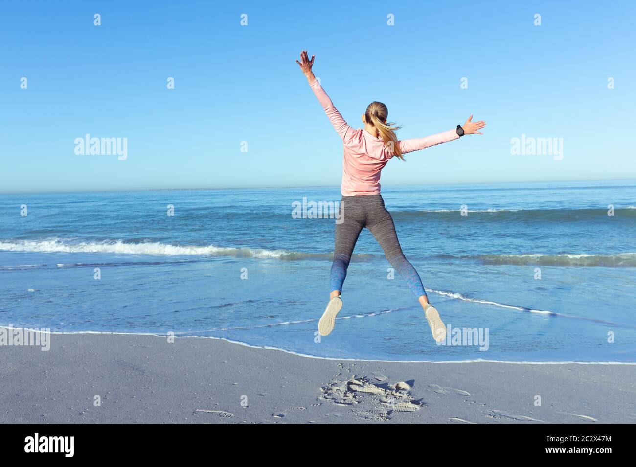 Kaukasische Frau, die Zeit am Meer mit Sportkleidung Stockfoto