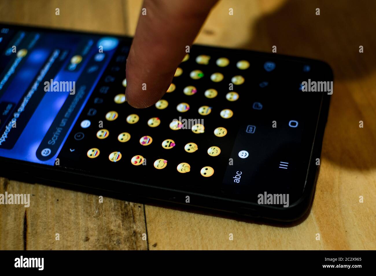 Mann surfen und tippen Sie auf Emoji-Symbole, Smartphone Messaging Emoticons Symbol Stockfoto