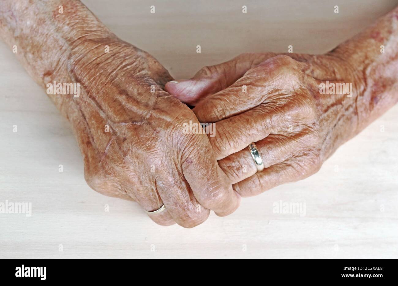 Die Hände einer sehr alten Frau. Die Hände der alten Frau auf einem Tisch. Hände der alten Frau mit Venen Stockfoto