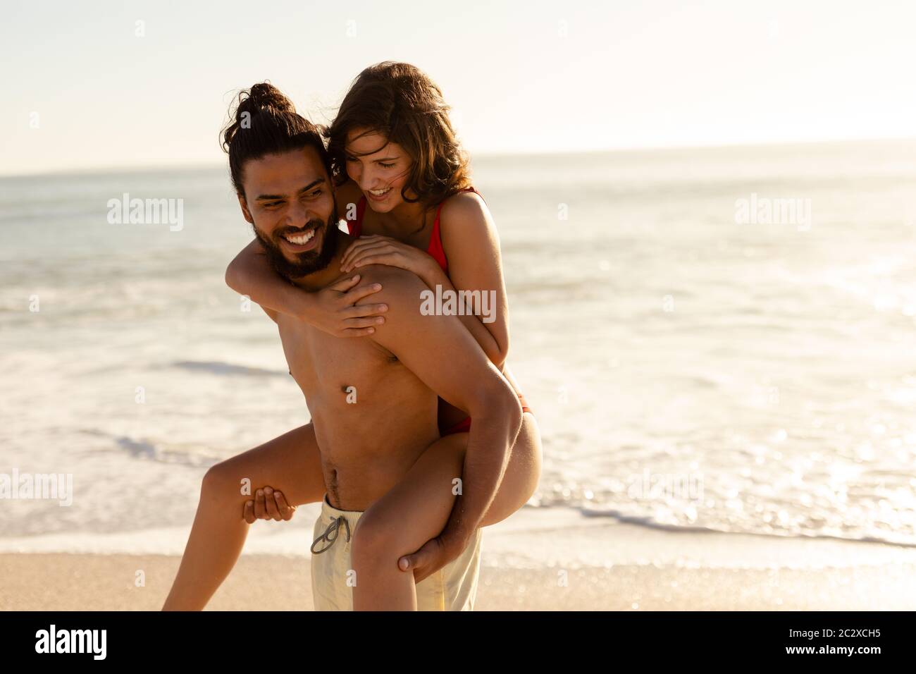 Multiethnisches Paar, das Spaß am Strand hat Stockfoto