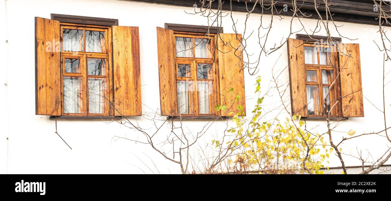 Fenster mit Fensterläden aus Holz in eine weiße Wand. Hintergrundbild. Für Text platzieren. Stockfoto