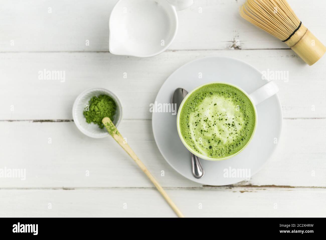 Matcha Latte Tasse auf weißem Hintergrund von oben. Dieser Latte ist eine köstliche Art, die Energie zu steigern und die gesunden Vorteile von Matcha zu genießen. Stockfoto