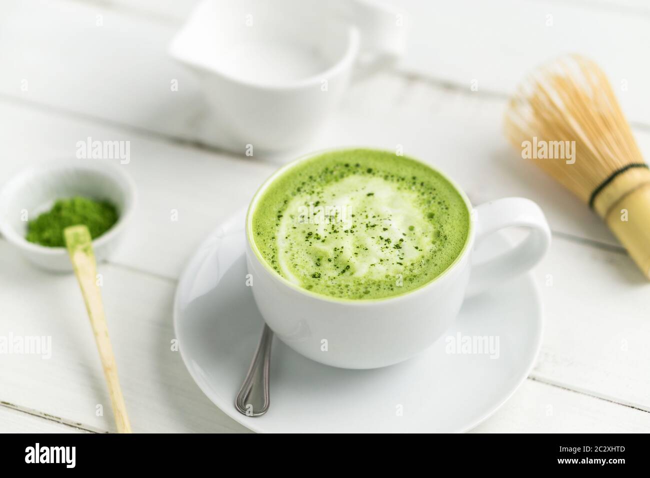 Grüner Tee Matcha Latte Tasse auf weißem Hintergrund. Dieser Latte ist eine köstliche Art, die Energie zu steigern und die gesunden Vorteile von Matcha zu genießen. Stockfoto