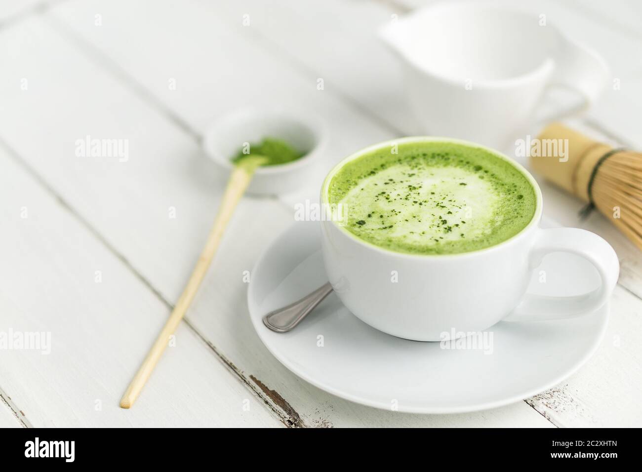 Grüner Tee Matcha Latte Tasse auf weißem Hintergrund. Dieser Latte ist eine köstliche Art, die Energie zu steigern und die gesunden Vorteile von Matcha zu genießen. Stockfoto