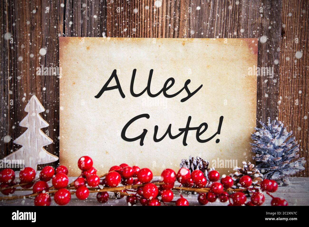 Papier mit deutschem Text alles Gute, die besten Wünsche. Weihnachtsdekoration und Holz- Hintergrund mit Schnee Stockfoto