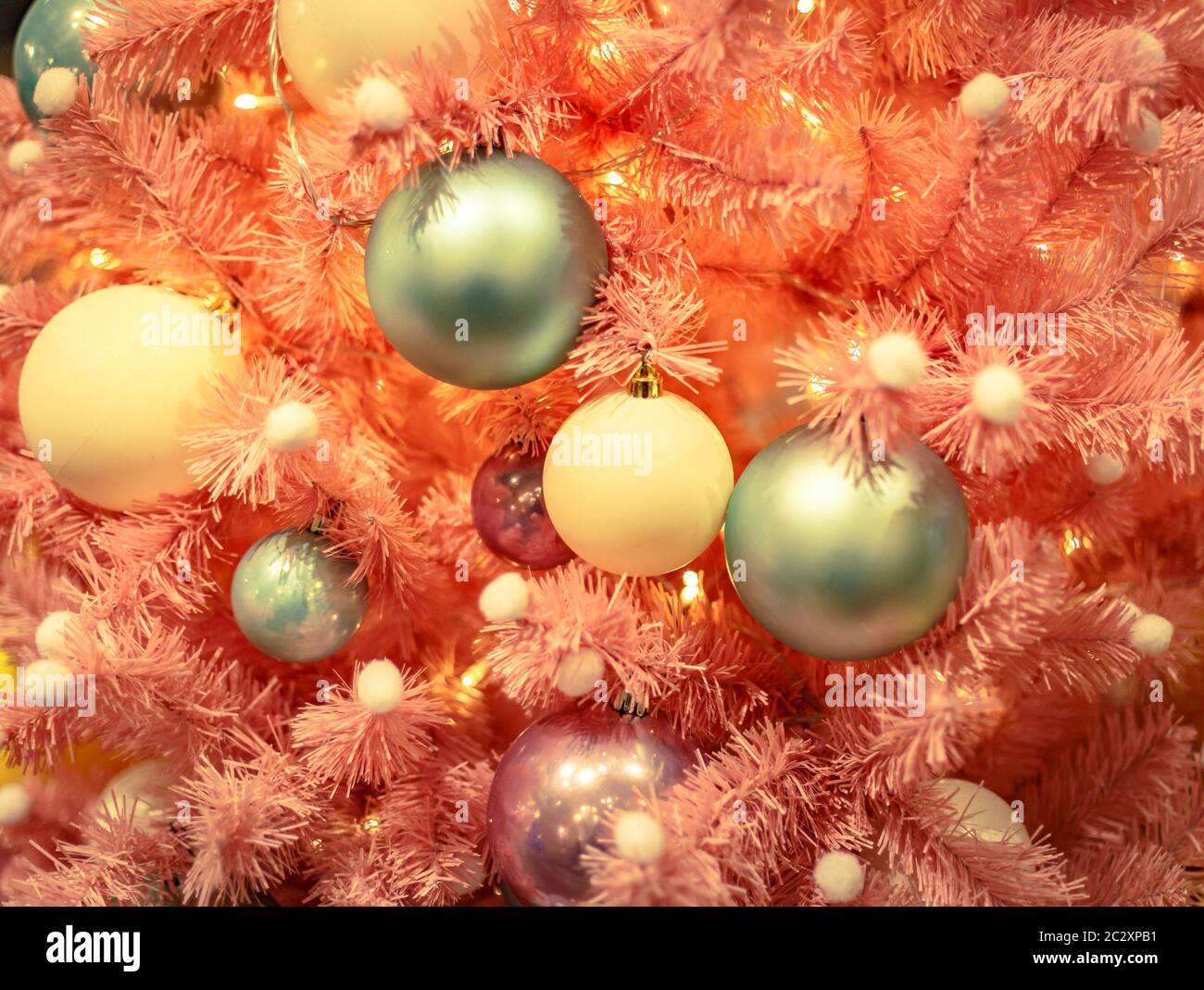 Weihnachtsbaum mit goldenen Kugeln Ornamente. Geschmückter Weihnachtsbaum aus der Nähe. Bälle und beleuchtete Girlande mit Taschenlampen. Neu Stockfoto