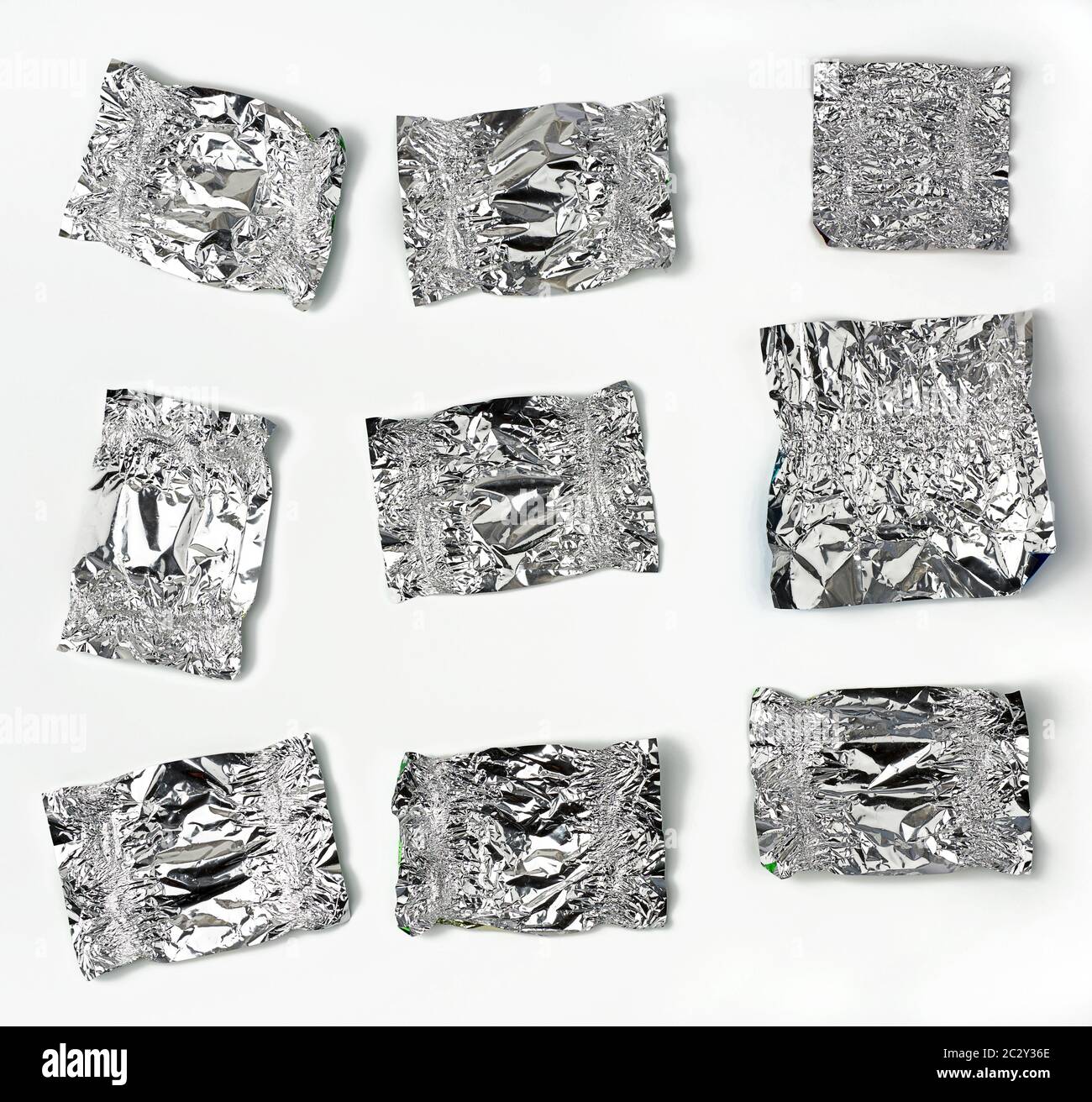 Verschiedene zerknitterte Folien verwendeten Süßigkeiten-Wrapper auf weißem Hintergrund, Draufsicht Stockfoto