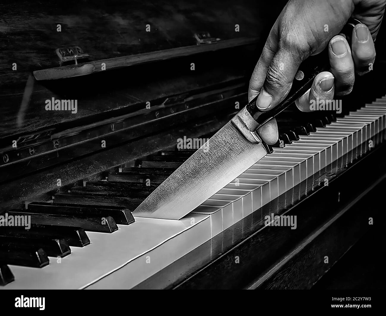 Surreales Bild eines Messers, das ein Klavier wie einen Kuchen schneidet Stockfoto