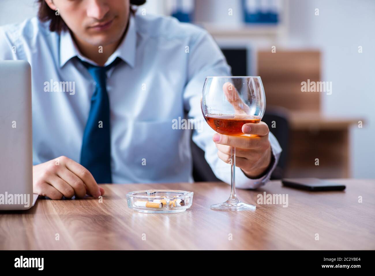 Männliche Mitarbeiter, Alkohol zu trinken und Zigaretten zu rauchen an workpla Stockfoto