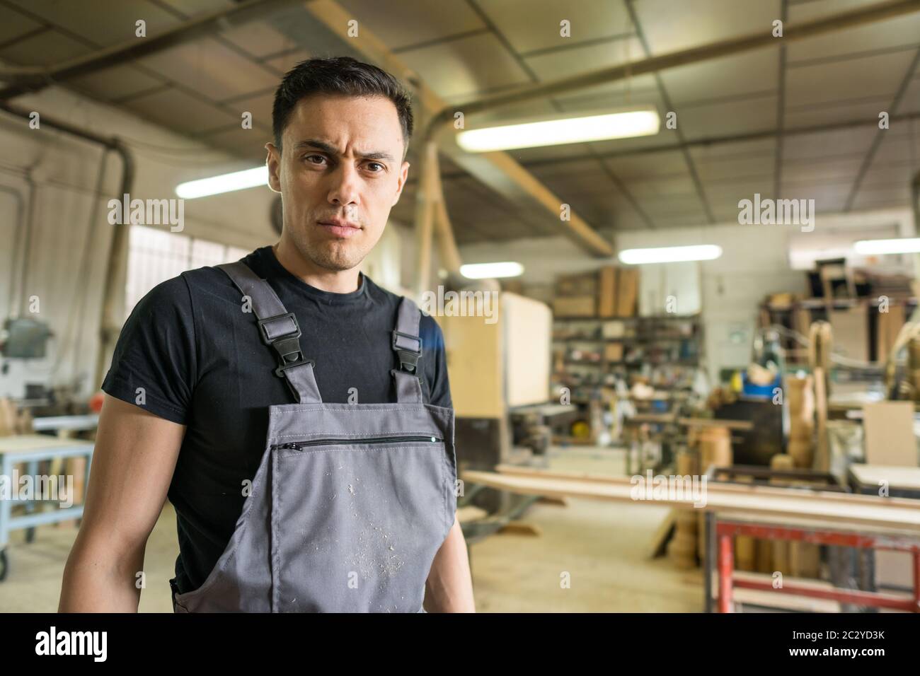 Arbeiter, der in einer Fabrik auf die Kamera schaut. Mittlerer Schuss. Stockfoto