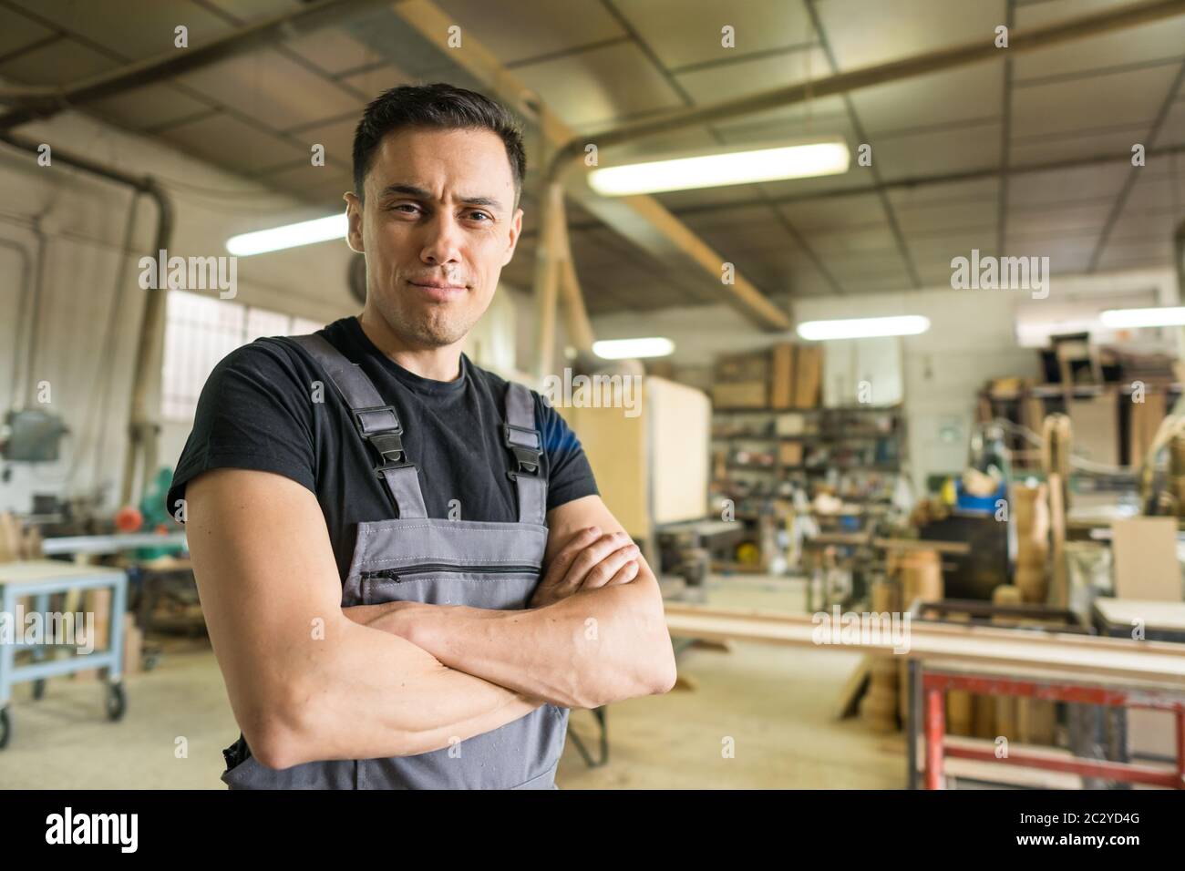 Arbeiter, der in einer Fabrik auf die Kamera schaut. Mittlerer Schuss. Stockfoto