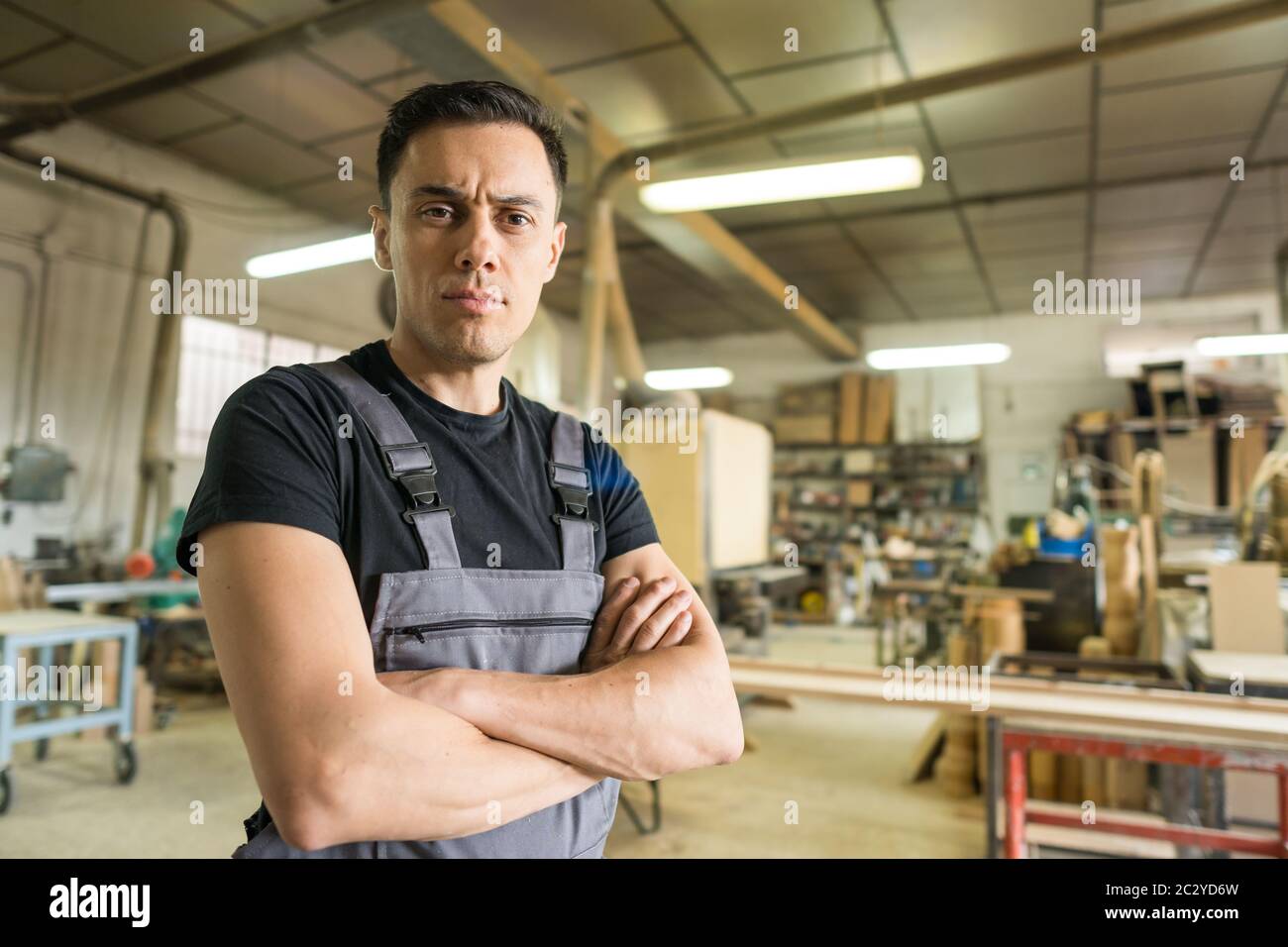 Arbeiter, der in einer Fabrik auf die Kamera schaut. Mittlerer Schuss. Stockfoto