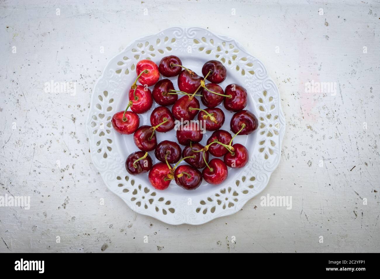 Rote Kirschen in einer Schüssel, auf einem stilvollen weißen Tisch Stockfoto