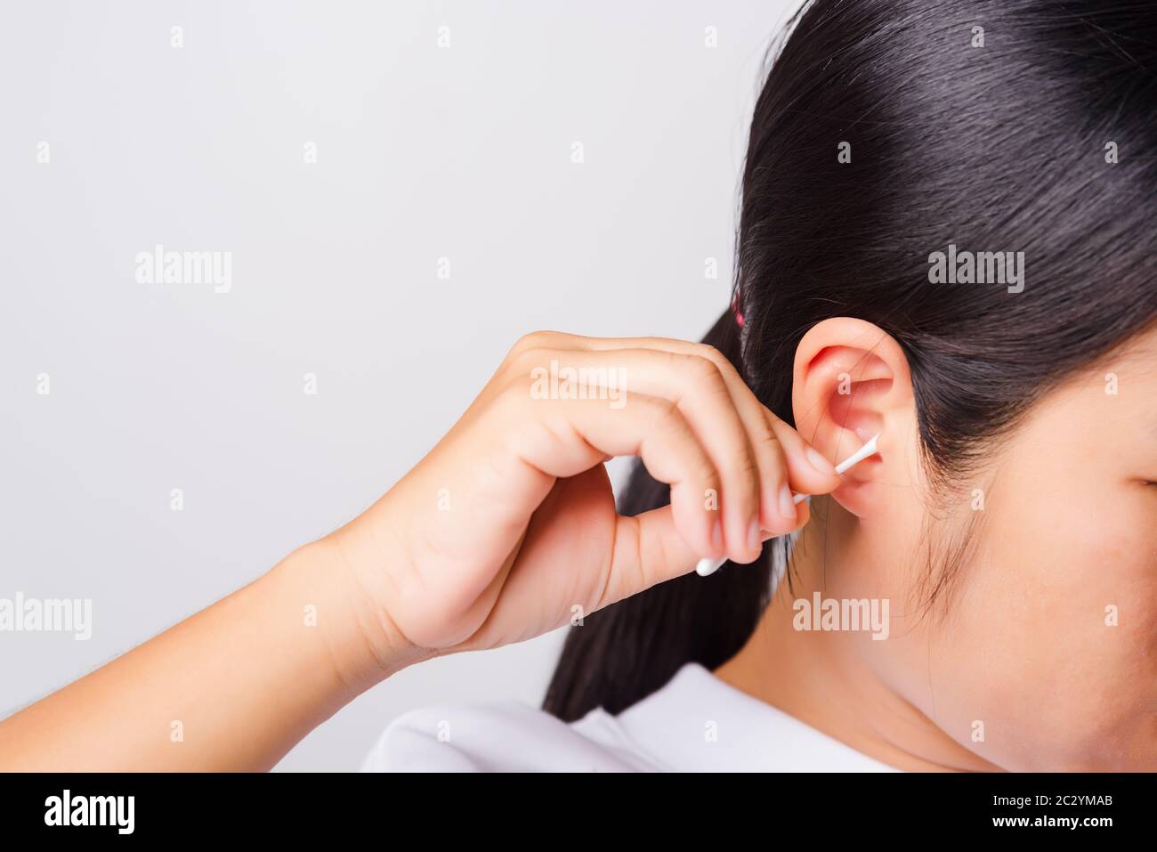 Asiatisch schöne Frau Reinigung Ohr hrt mit Wattestäbchen auf weißem Hintergrund mit Kopie Spece für Text, Healthcare Konzept Stockfoto