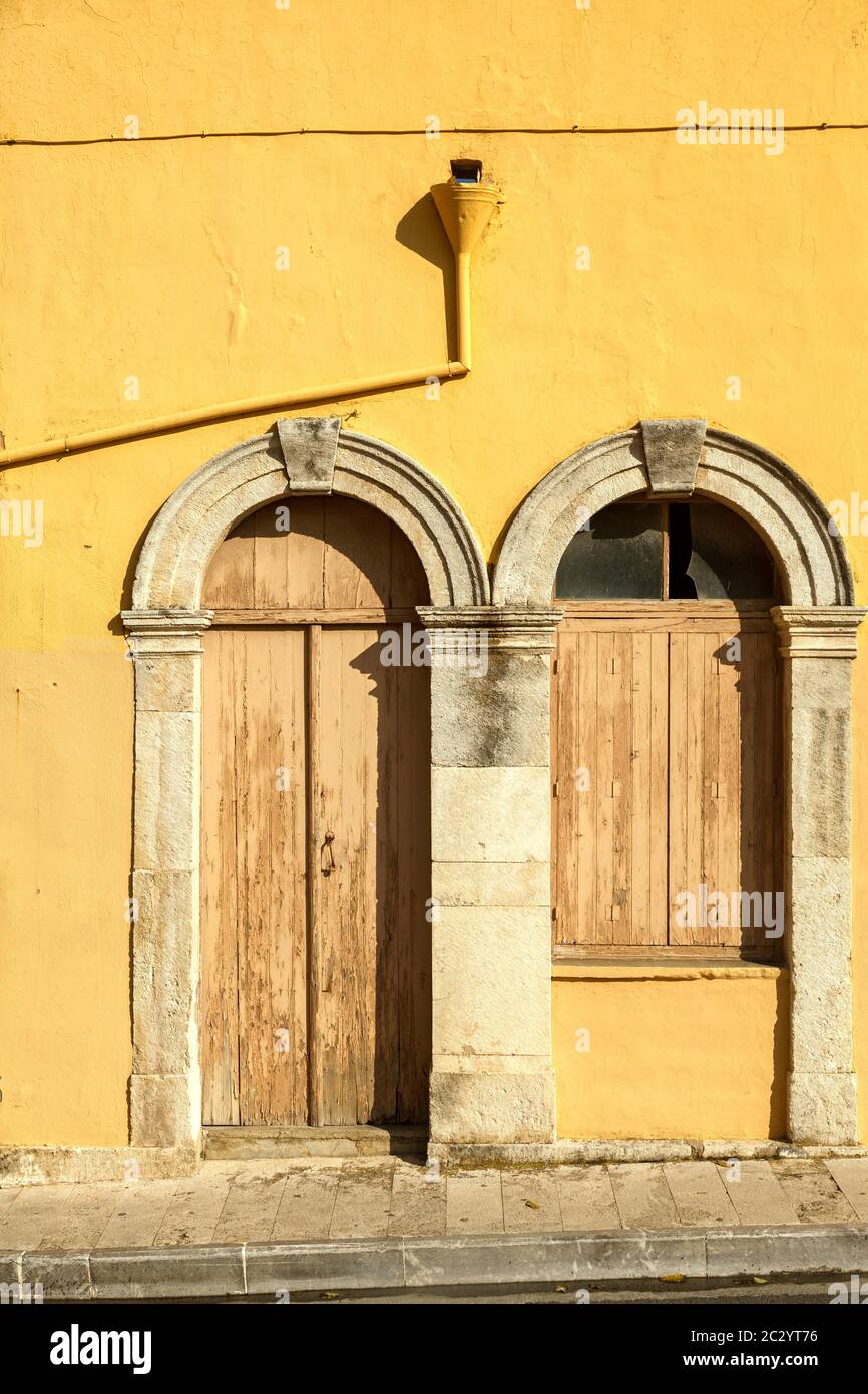 Traditionelle Türen über der gelben Mauer in Archanes Dorf, Heraklion Region, Kreta Insel, Griechenland, Europa. Stockfoto