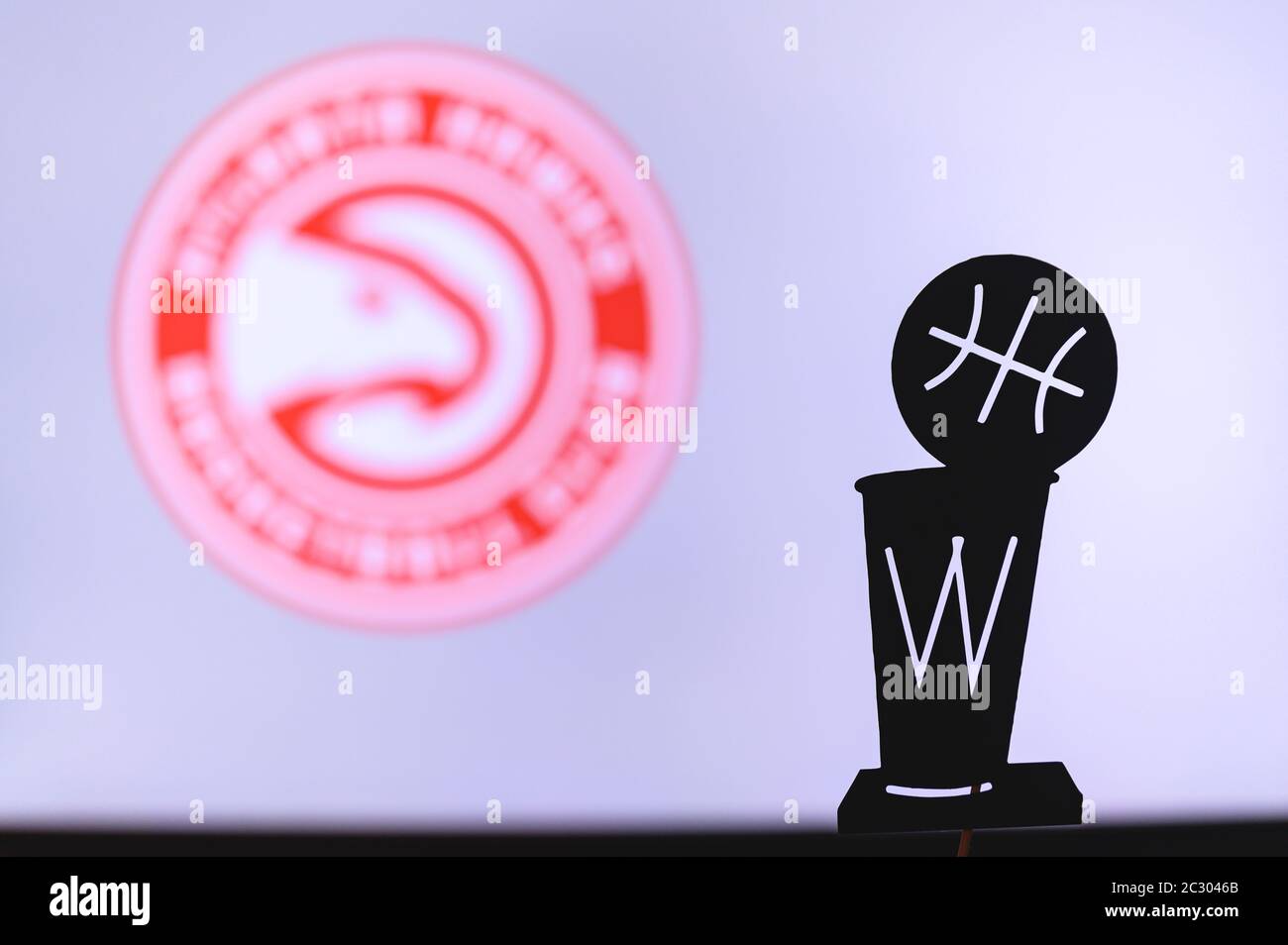 NEW YORK, USA, 18. JUN 2020: Atlanta Hawks Basketball Club auf der weißen Leinwand. Silhouette der NBA-Trophäe im Vordergrund. Stockfoto