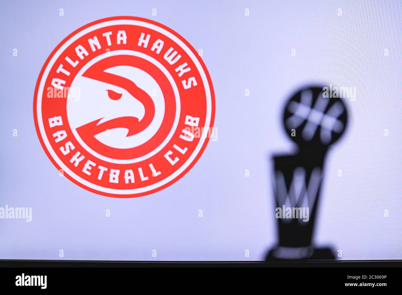 NEW YORK, USA, 18. JUN 2020: Atlanta Hawks Basketball Club auf der weißen Leinwand. Silhouette der NBA-Trophäe im Vordergrund. Stockfoto