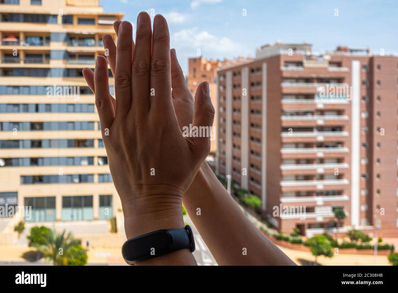 Menschen klatschen mit den Händen, applaudieren vom Balkon, um Ärzte, Krankenschwestern, Krankenhausangestellte während der Quarantäne der Coronavirus-Pandemie zu unterstützen Stockfoto