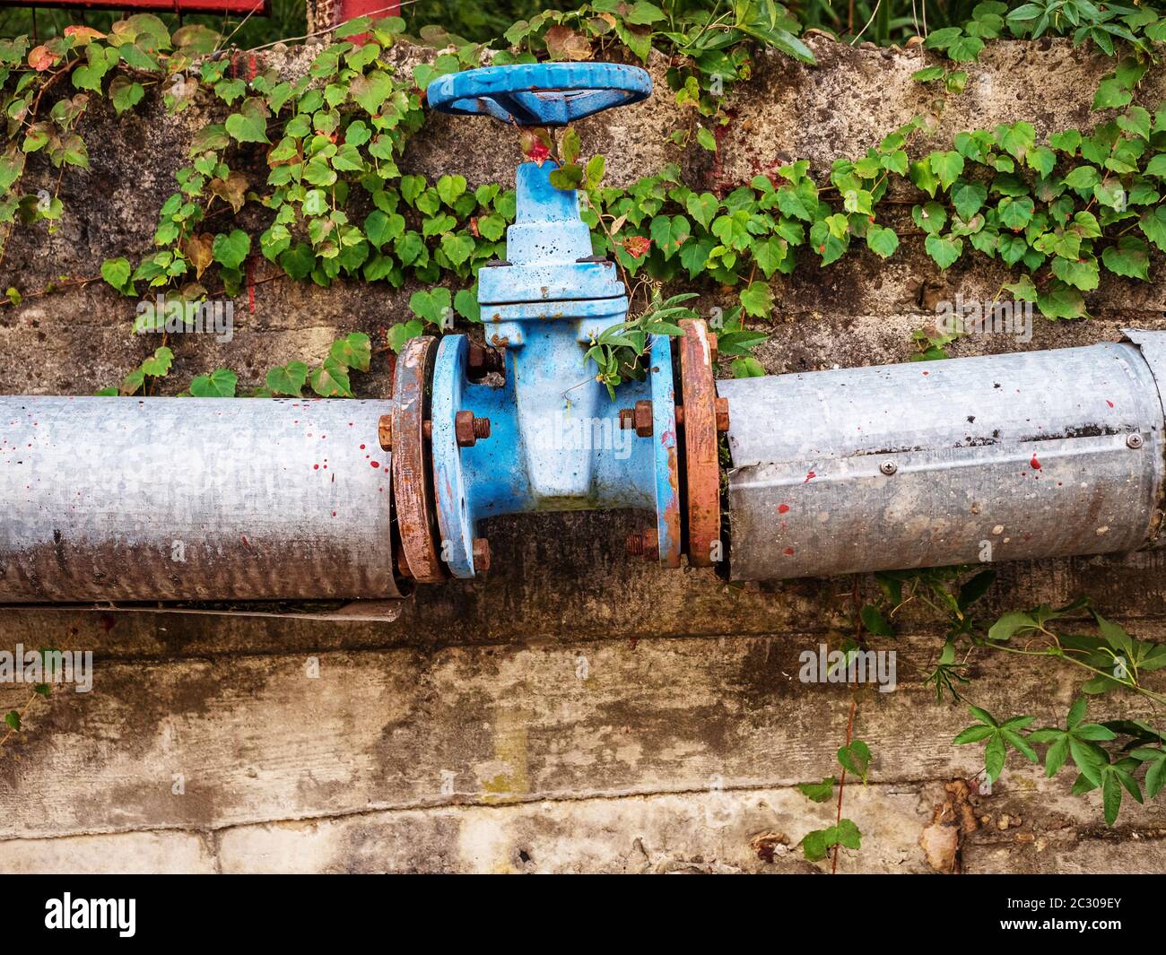 Großes blaues Rundventil mit Rohren zum Schließen des Wassers Stockfoto