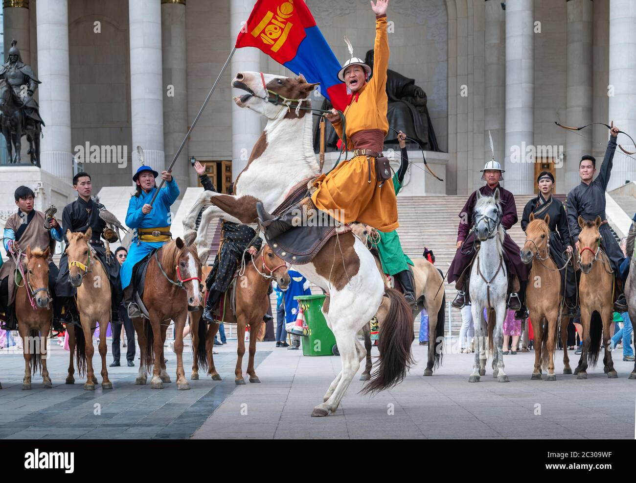 Junger Reiter Mann ein aufsteigendes Pferd vor dem Parlamentsgebäude während DES NAADAM Festivals, Ulaanbaatar Stadt, Mongolei Stockfoto