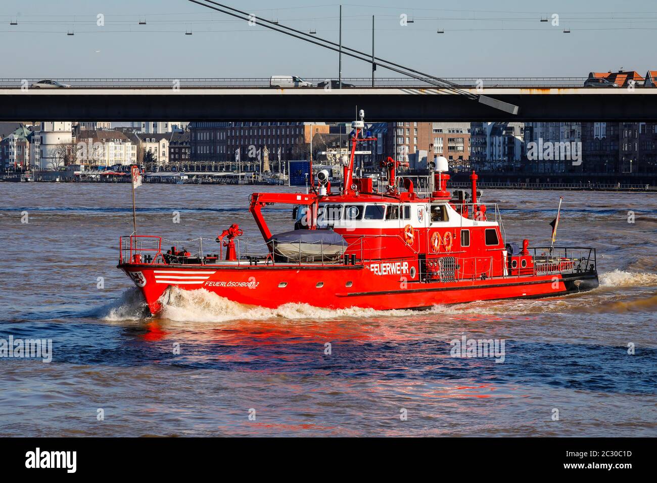 Feuerboot fährt auf dem Rhein bei Hochwasser unter der Rheinkniebrücke, Düsseldorf, Nordrhein-Westfalen, Deutschland Stockfoto