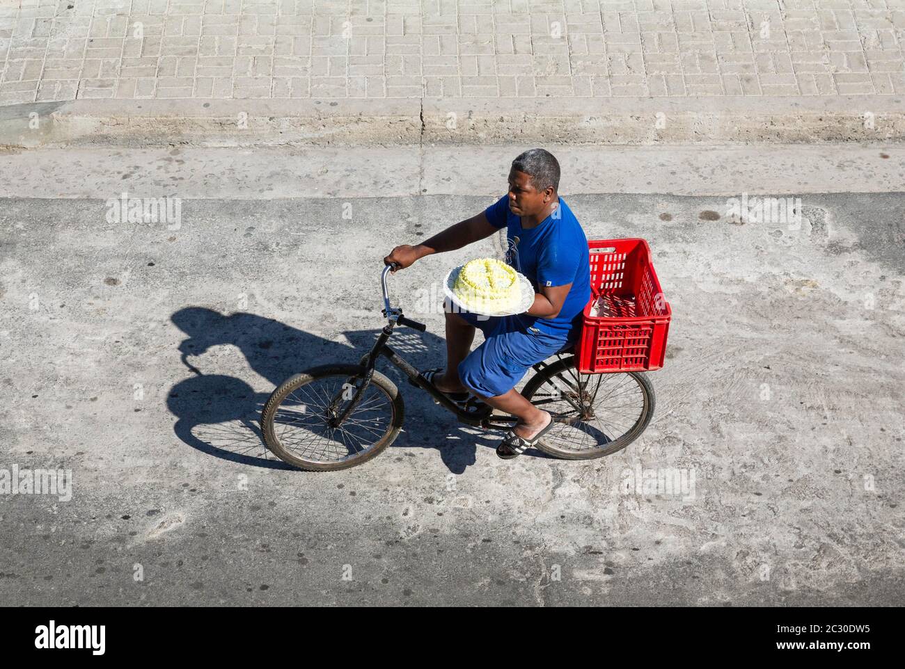 Mann auf einem Fahrrad versucht, einen Kuchen zu verkaufen, Santiago de Cuba, Kuba Stockfoto