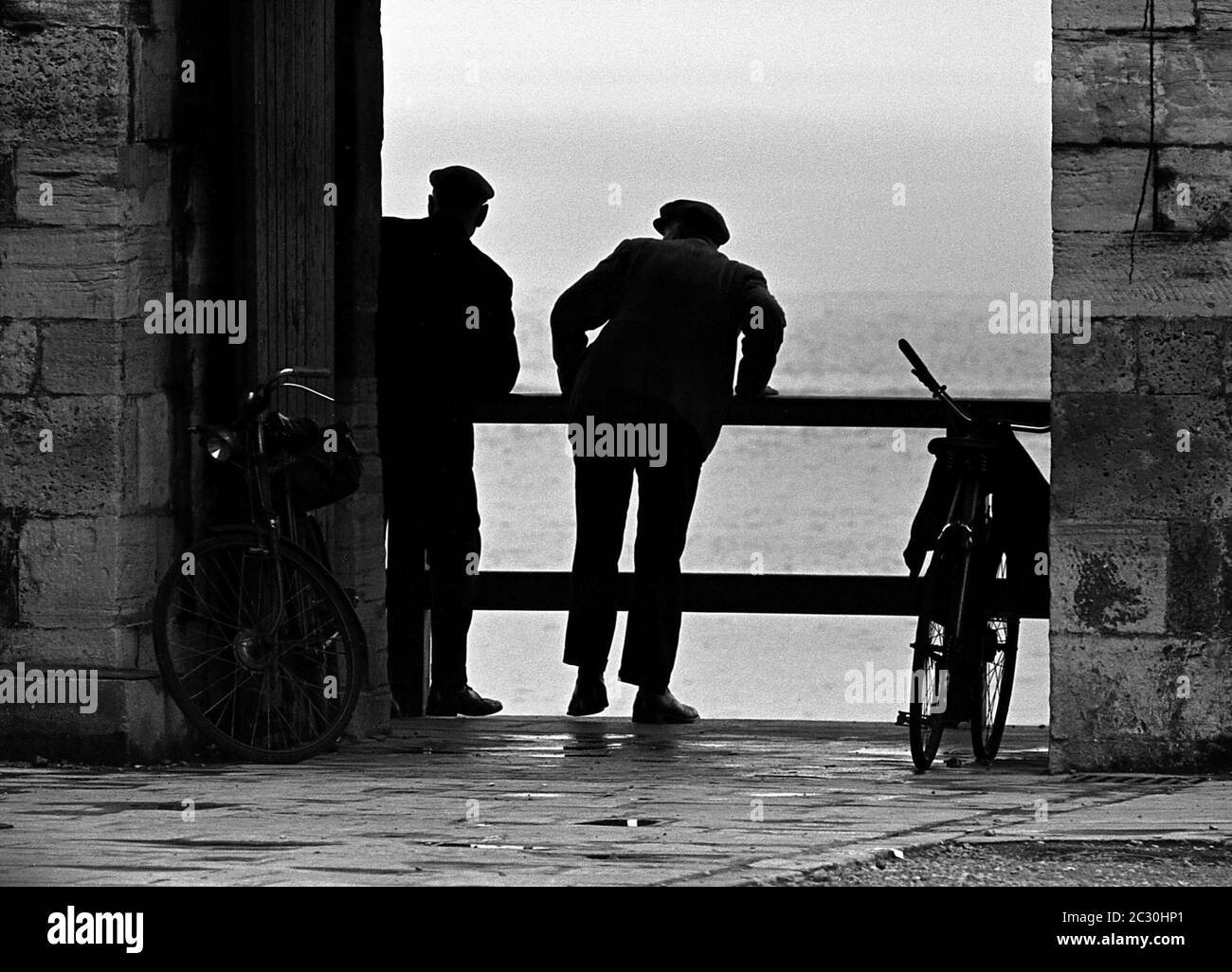 AJAXNETPHOTO. MAI 1969. OLD SALLY PORT, OLD PORTSMOUTH, ENGLAND. - WAS IST DAS! - ZWEI HERREN HABEN SICH ANSTRENGT, EINEN BESSEREN BLICK AUF DIE SICH ABZEICHNENDEN EREIGNISSE ZU BEKOMMEN. DER VIZEADMIRAL HORATIO NELSON SETZTE SICH ZULETZT AUF ENGLISCHEN BODEN, ALS ER DURCH DIESES LOCH IN DEN HEISSEN MAUERN HINDURCH GING, BEVOR ER IM SEPTEMBER 1805 MIT DEM START ZUM HMS-SIEG UND DER SCHLACHT VON TRAFALGAR AUFTRAT. FOTO: JONATHAN EASTLAND/AJAXREF:356917 10A 45 Stockfoto