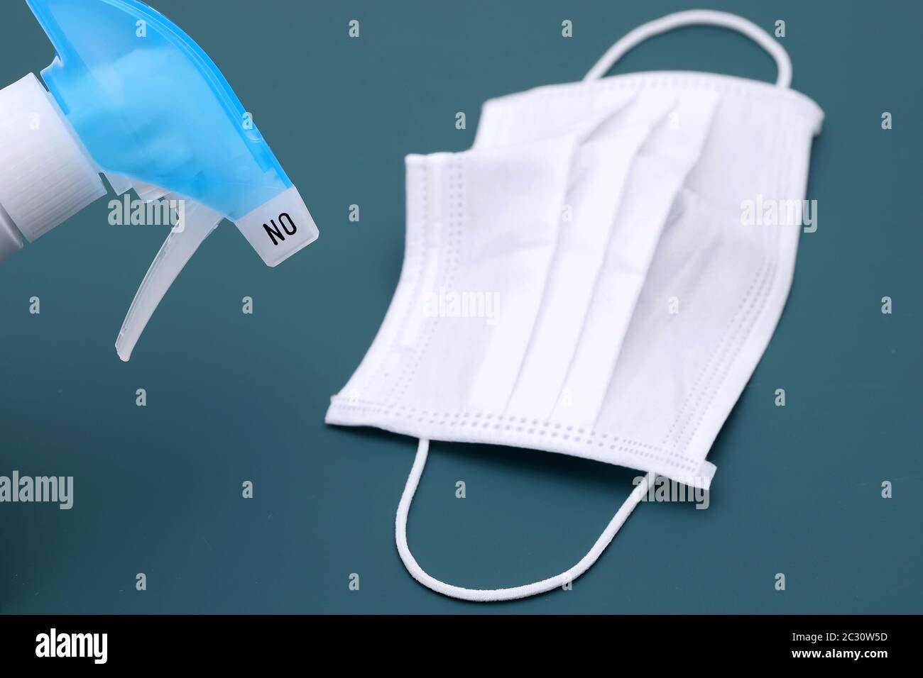 Desinfektionsspray mit Schutzmaske auf dem Farbhintergrund Stockfoto