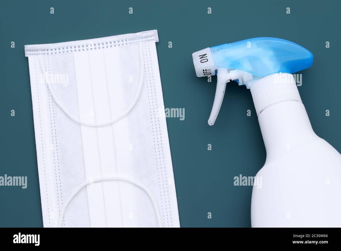 Desinfektionsspray mit Schutzmaske auf dem Farbhintergrund Stockfoto