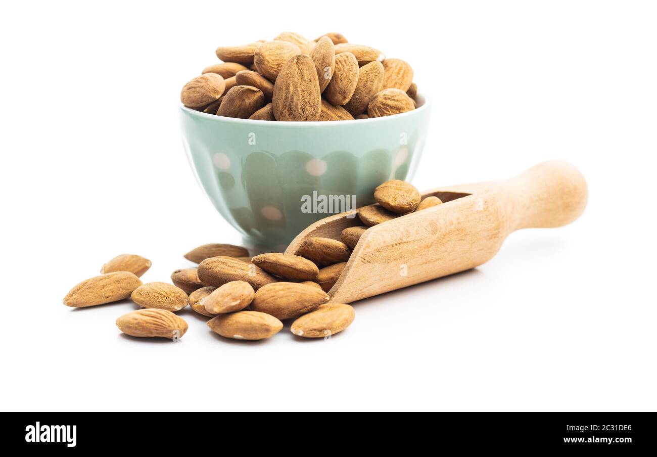 Getrocknete Mandeln Nüsse in der Schüssel und Holzschaufel isoliert auf weißem Hintergrund. Stockfoto