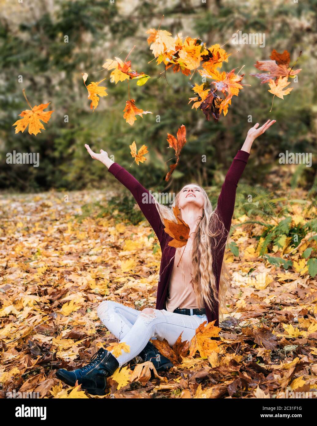 Ansicht einer Frau, die mit Blättern spielt, Bainbridge Island, Washington, USA Stockfoto