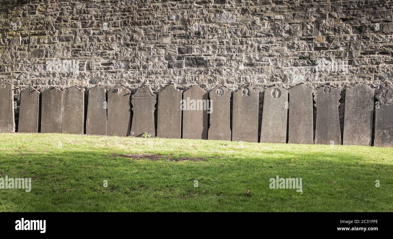 Dublin, Irland - 13. Februar 2019: Grabsteine, die an einer Mauer auf dem Friedhof auf dem Arbor Hill neben der Kirche des Heiligen Herzens an einem Winter d gelegt wurden Stockfoto