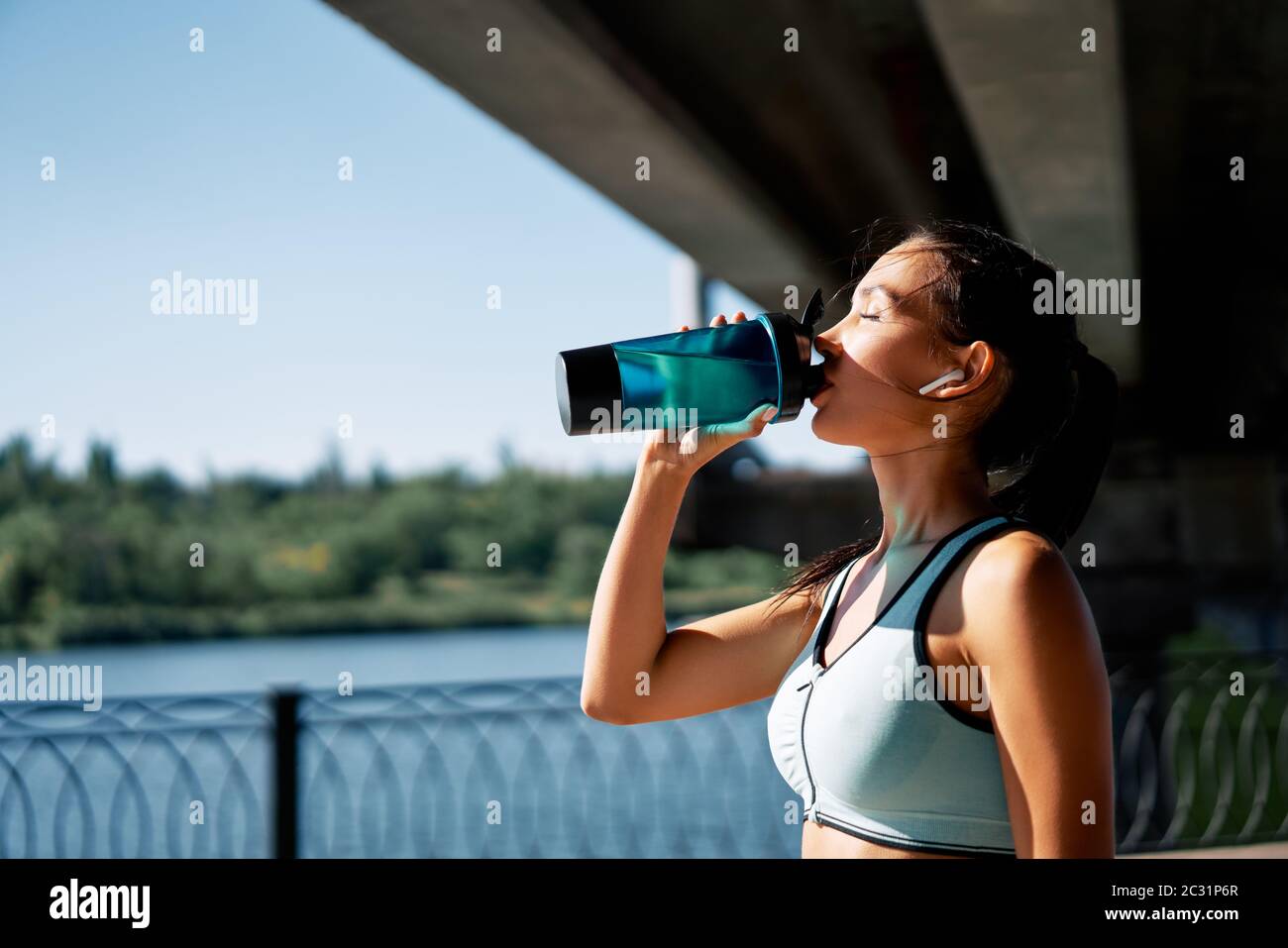 Junge Fitness Frau Trinkwasser aus der Flasche Stockfoto