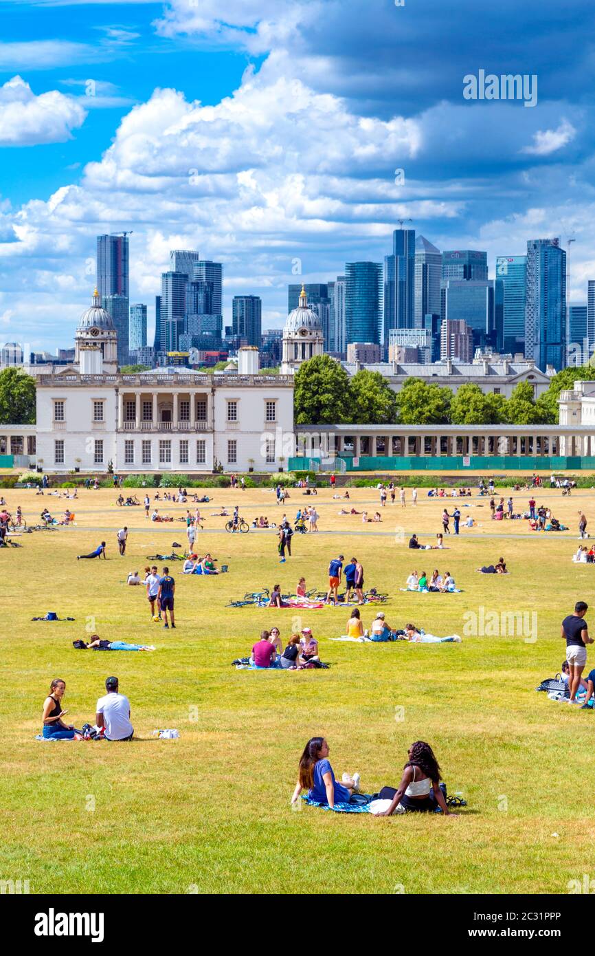 Picknicken auf dem Rasen im Greenwich Park mit Panoramablick auf Canary Wharf, London, Großbritannien Stockfoto