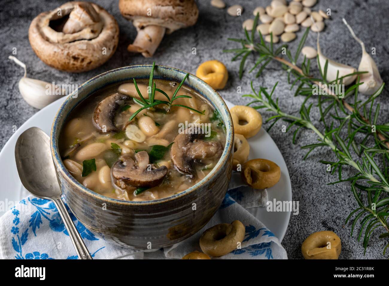 Vegane Suppe. Portobello Pilze, Cannellini Bohnen und Knoblauch mit Rosmarin Taralli Cracker. Stockfoto