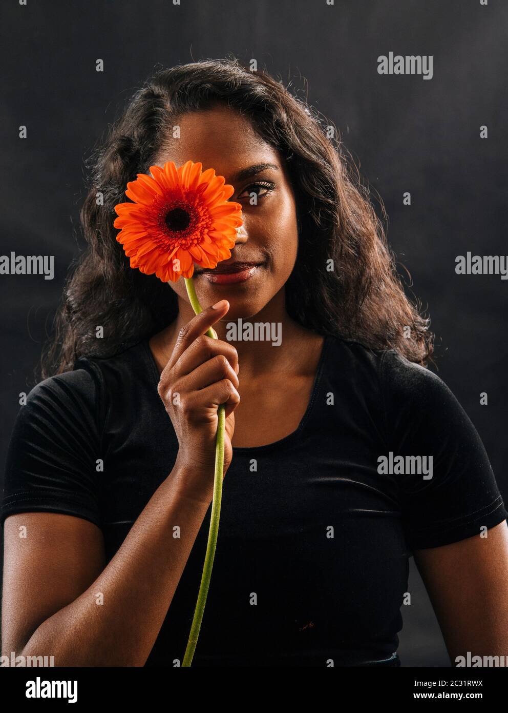 Lächelnde Frau Holding Blume Stockfoto