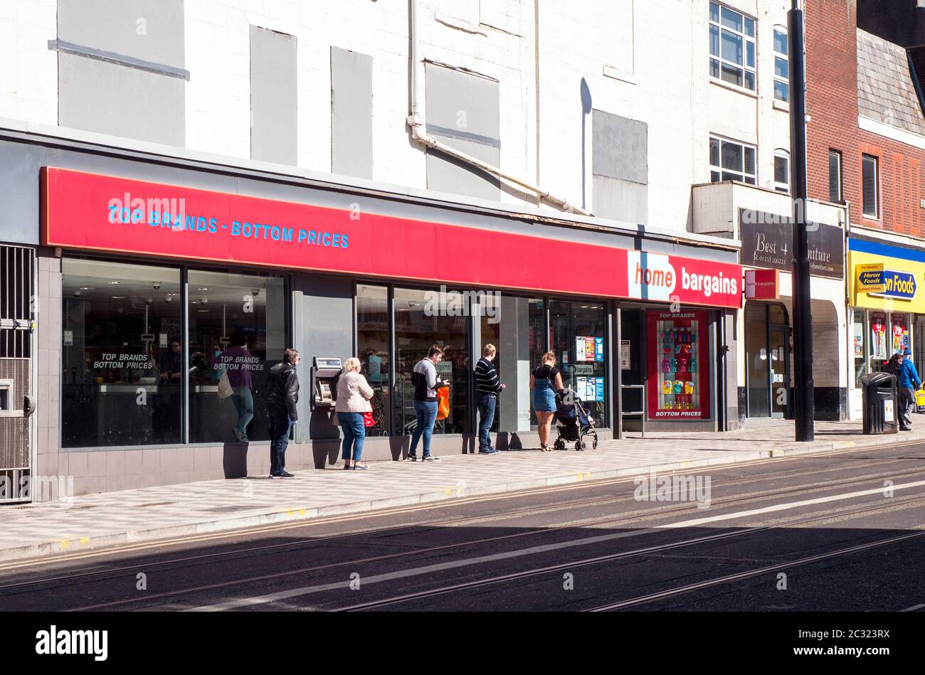 Shopper soziale Distanzierung während der Schlange früh am Morgen im Home Schnäppchen Geschäft auf Talbot Road Blackpool Lancashire England während Covid 19 Ausbruch. Stockfoto