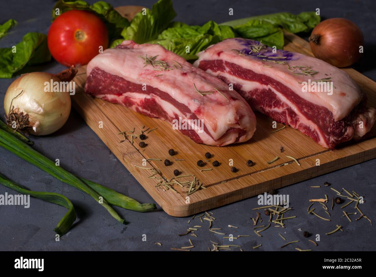 Argentinisches rohes Fleisch auf einem Holztisch mit Gemüse Stockfoto