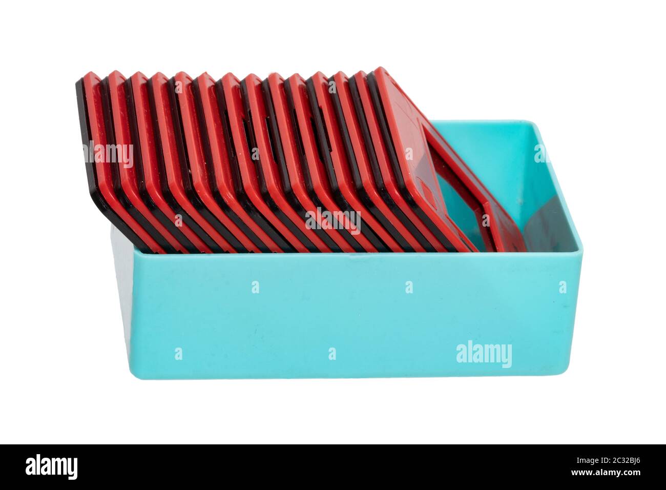 Nahaufnahme einer türkisfarbenen Kunststoffbox mit rot und schwarz gerahmten Folienfolien isoliert auf weißem Hintergrund. Unterhaltung im letzten Jahrhundert, um Urlaub p Stockfoto