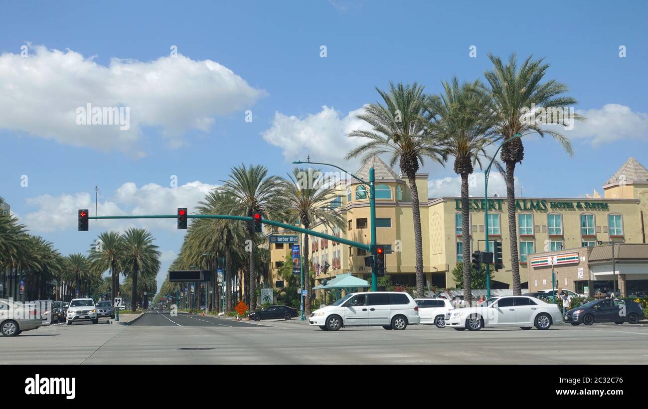 Stadtbild an der Kreuzung von Katella und Hafen, mit blauem Himmel, Palmen und dem neuen Desert Palms Hotel Stockfoto