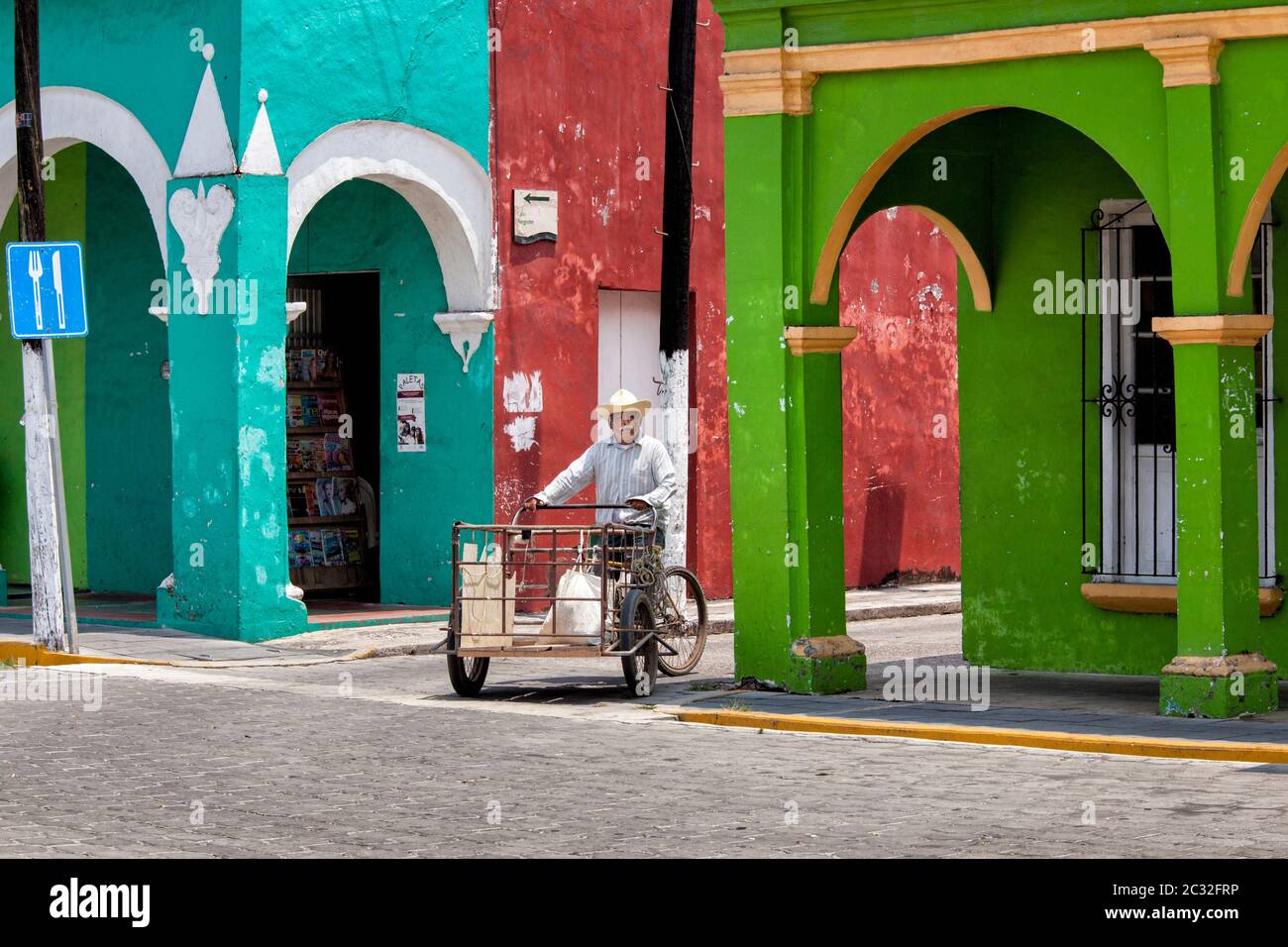 Ein Mann auf einem Fahrrad verwendet, um kleine Ladung in bunten Tlacotalpan, Veracruz, Mexiko zu transportieren. Stockfoto