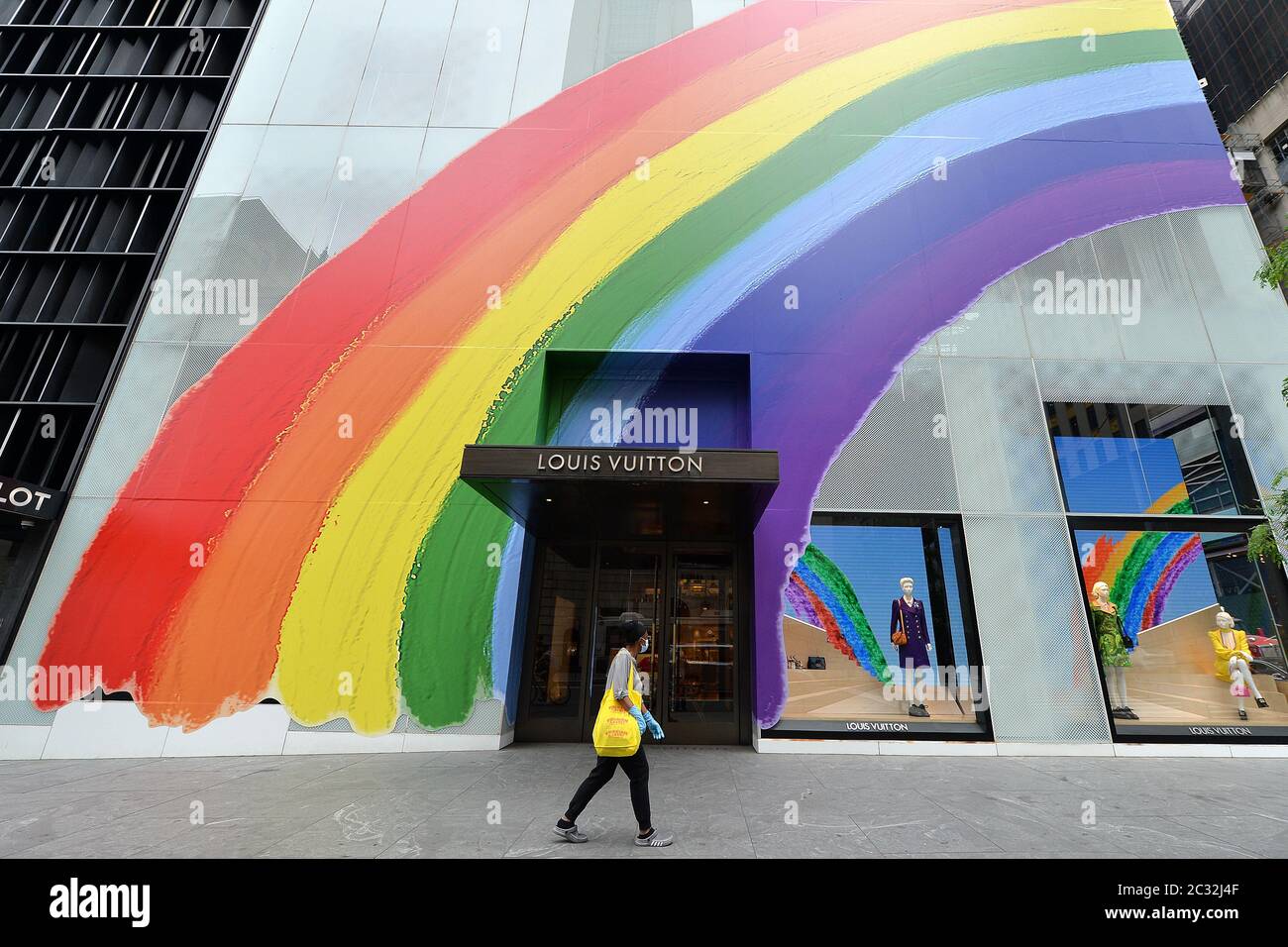 New York City, USA. Juni 2020. Eine Frau kommt an einem neu eröffneten Louis Vuitton 5th Ave. Flagship-Store vorbei, der am 18. Juni 2020 zu Ehren des „Pride Month“ in New Yrok, NY, mit einem großen Regenbogen dekoriert ist. Nach fast drei Monaten der Sperrung, unter Phase 1 der Wiedereröffnung, sind die Baumaßnahmen, der Einzelhandel, die Fertigung und der Großhandel in New York City wieder erlaubt, Phase 2 beginnt am 22. Juni. (Anthony Behar/Sipa USA) Quelle: SIPA USA/Alamy Live News Stockfoto