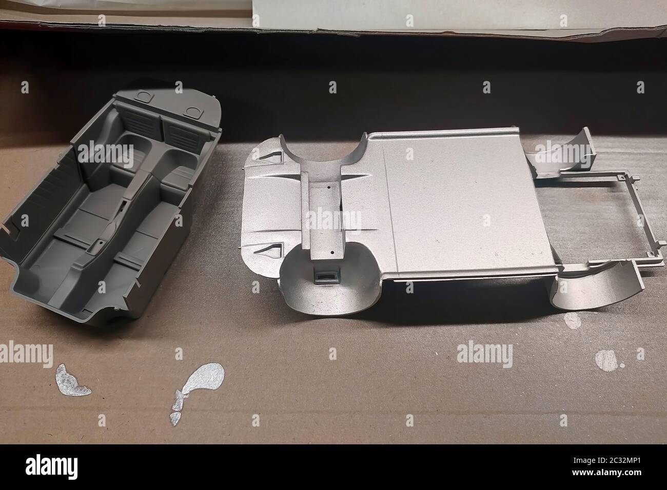 Nicht grundierte und grundierte Teile eines Modellautos für die Montage. Karosserie und Innenraum. Modellierung. Malen eines Spielzeugautos. Stockfoto