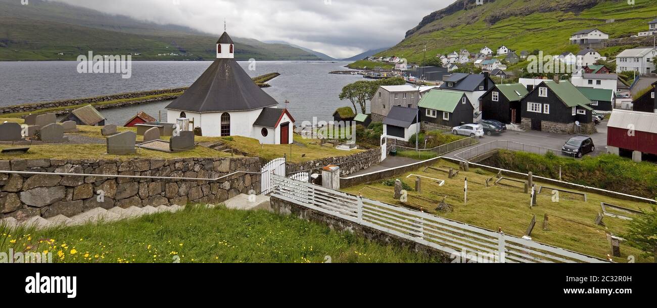 Die kleine Stadt Haldarsvik mit der achteckigen Kirche und Blick auf den Atlantik, Färöer, Dänemark Stockfoto