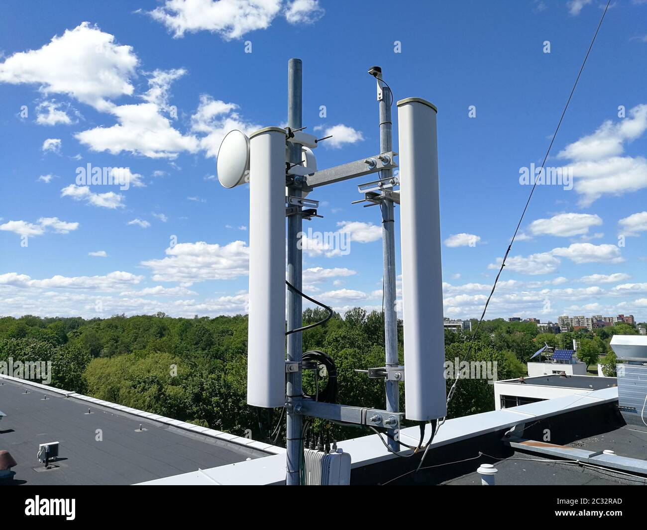 GSM (Global System for Mobile Communication) Basisstation und Repeater Tower vor blauem wolkenfreiem Himmel für Telekommunikation Stockfoto