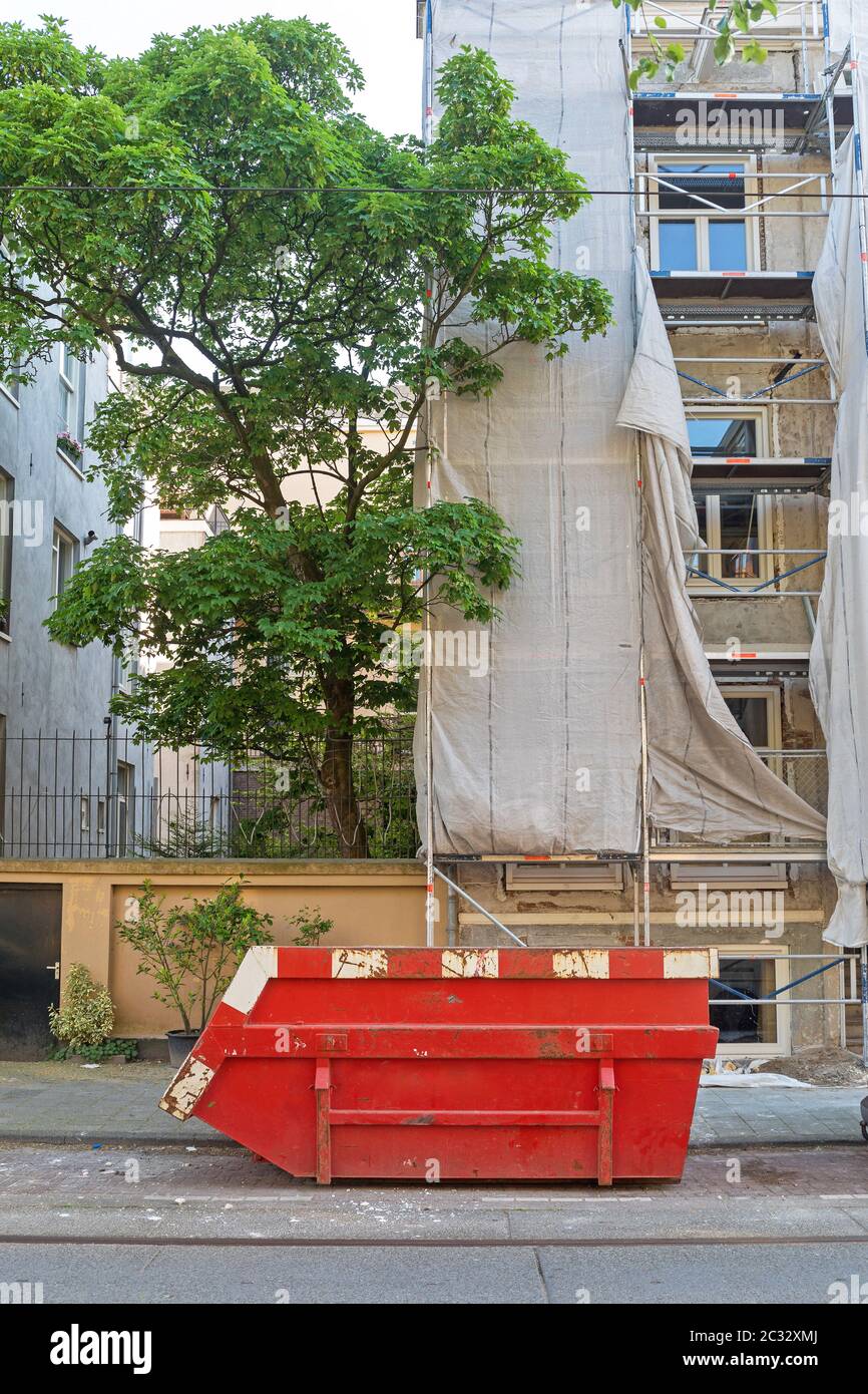 Große Rote überspringen Container an der Baustelle in der Stadt Stockfoto