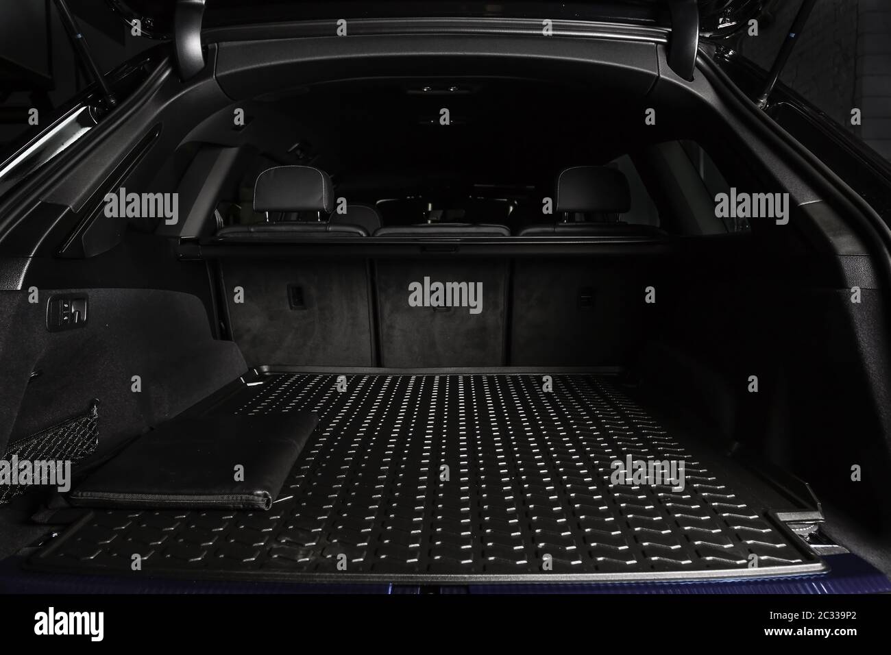 Der große schwarze leere Kofferraum des SUV-Autos mit Gummimatte