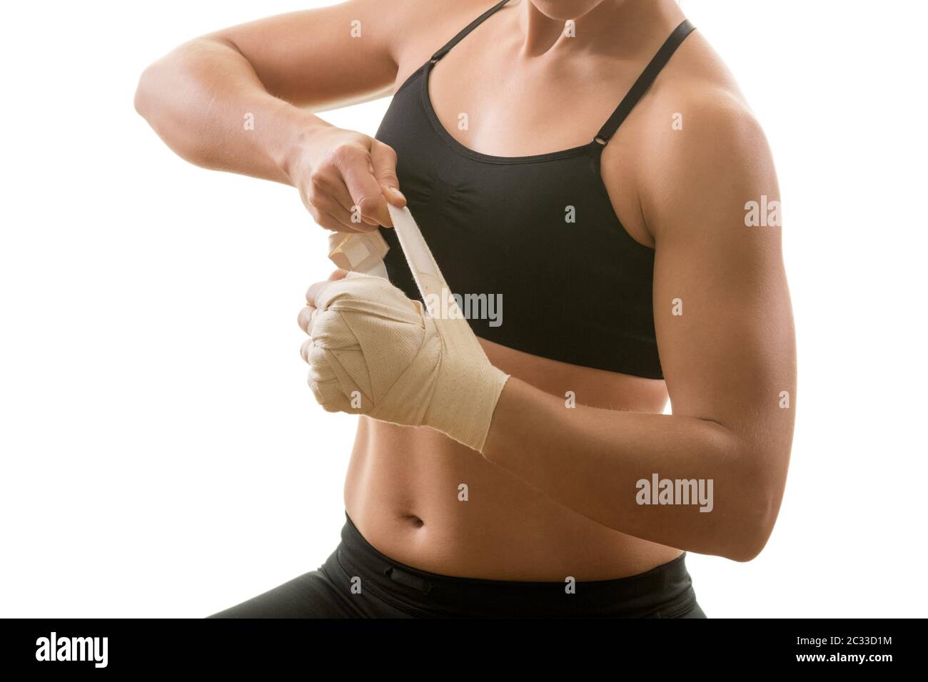 Junge muskulöse starke Frau, die sich auf Bandage setzt, isoliert auf weißem Hintergrund. Kampfkunst, Fitness, Gewichtsverlust. Stockfoto