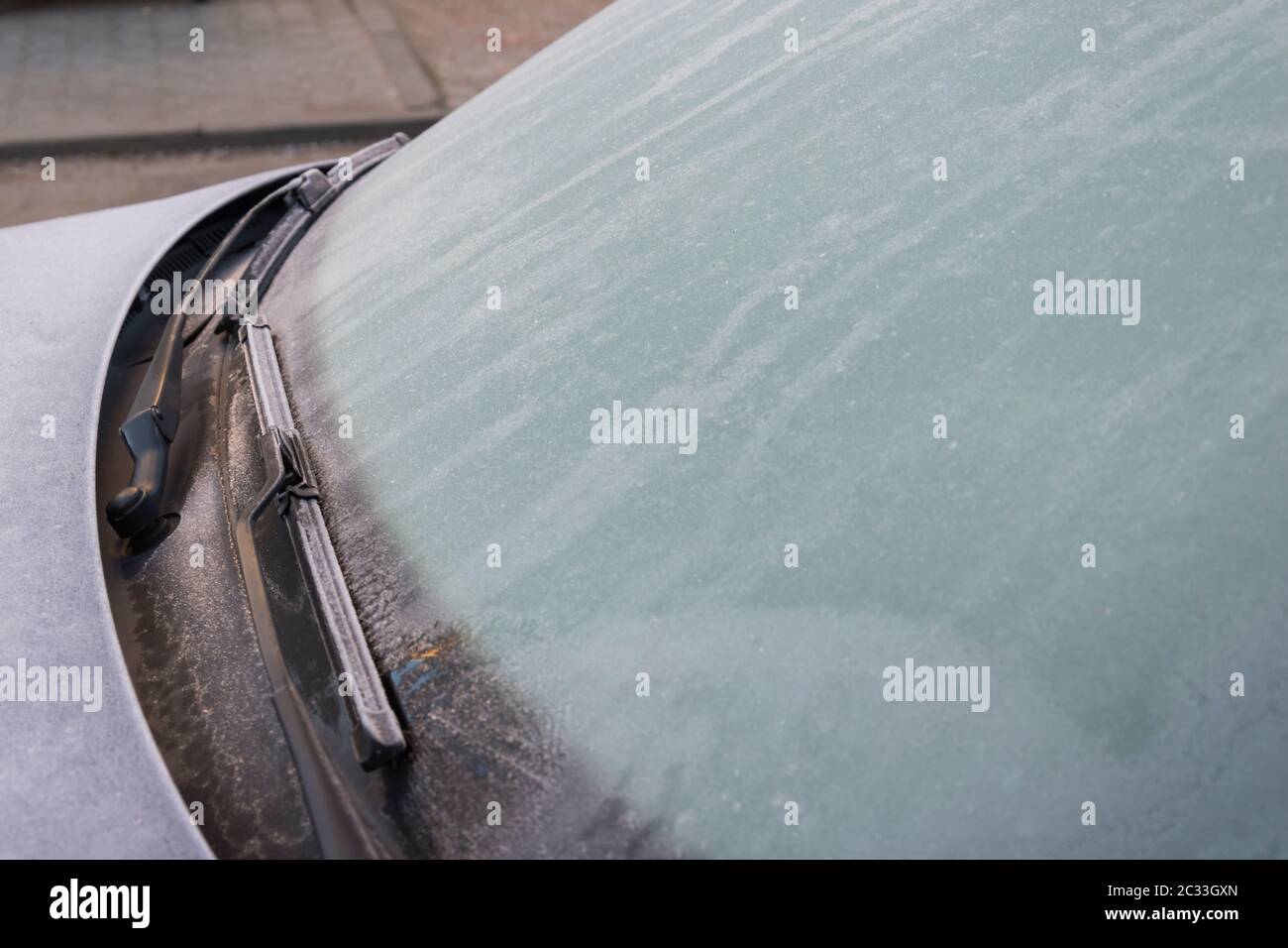 Gefrorene auto Windschutzscheibe mit Eis und Schnee an einem Wintertag abgedeckt. Nahaufnahme. In der Nähe des gefrorenen Windschutzscheibe und Scheibenwischer im Winter Stockfoto